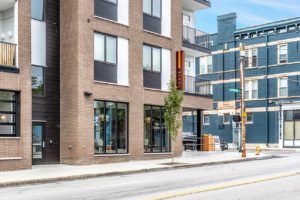 Illuminated Orange Blade Sign at Poste Apartments