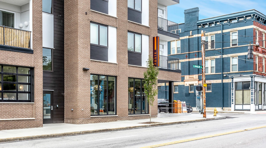 Illuminated Orange Blade Sign at Poste Apartments